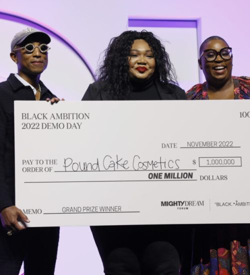 NORFOLK, VIRGINIA - NOVEMBER 03:  (L-R) Pharrrell Williams, Camille Bell, Co-Founder of Pound Cake Cosmetics, and Felecia Hatcher pose onstage during the "Dinner With A Purpose" Event Hosted By Black Ambition At Mighty Dream Forum 2022 on November 03, 2022 in Norfolk, Virginia. (Photo by Jemal Countess/Getty Images for Mighty Dream Forum)